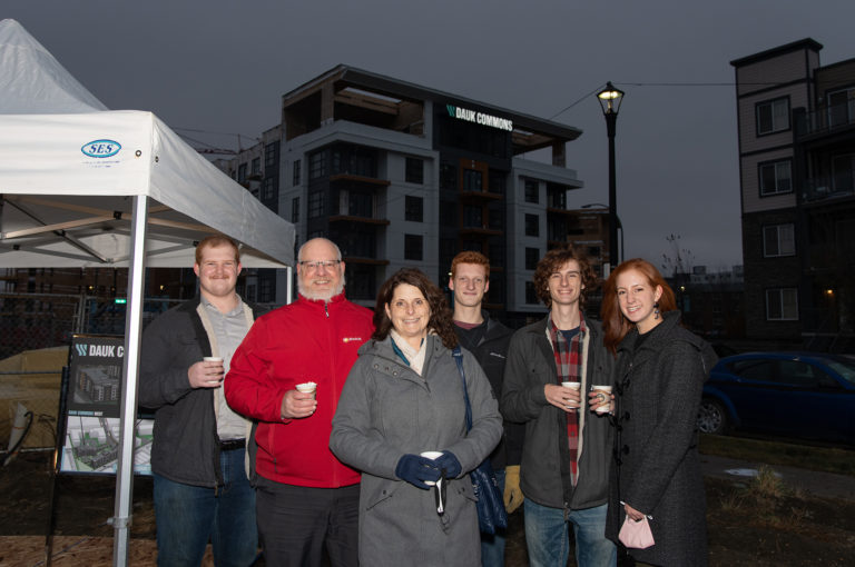 6 people standing beside a white tent in Dauk Commons.