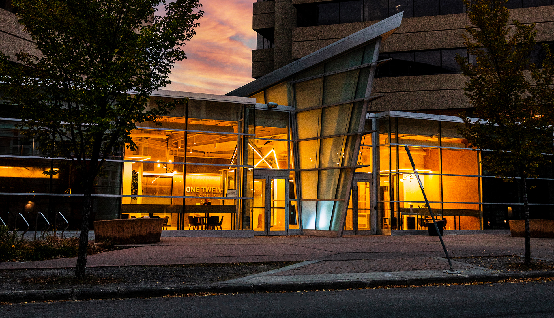 One Twelve Campus photo from outside at dawn with illuminated halls and entrances.