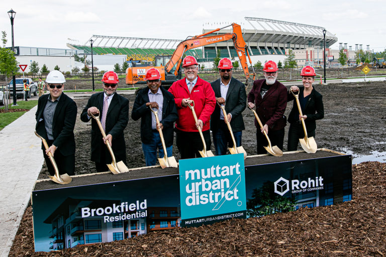 7 Rohit team members with hardhats each holding a golden shovel